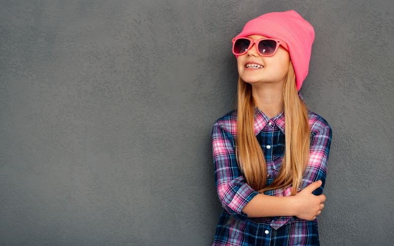 Young individual wearing sunglasses and stocking hat