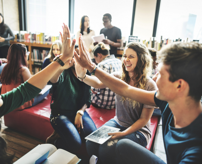 Individuals giving a group high-five.