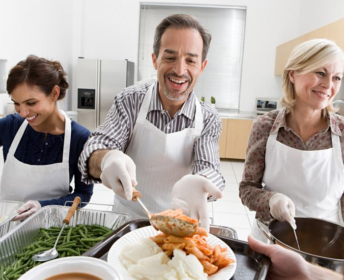 Man volunteers to serve pasta.